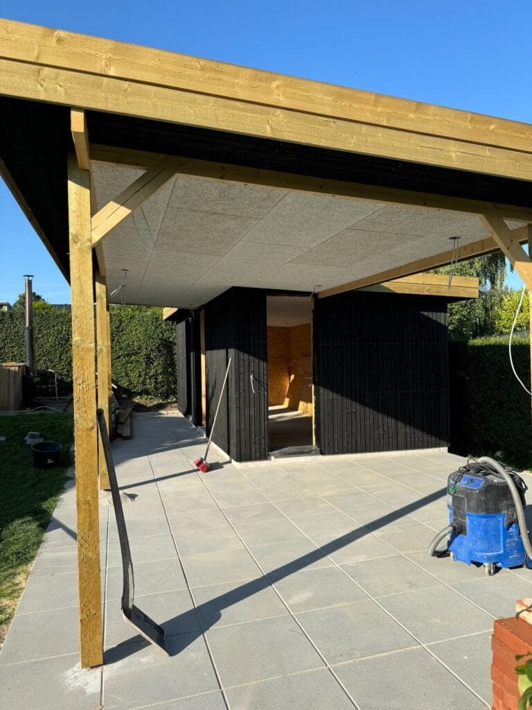 Nybygget carport med flisebelægning i solskin