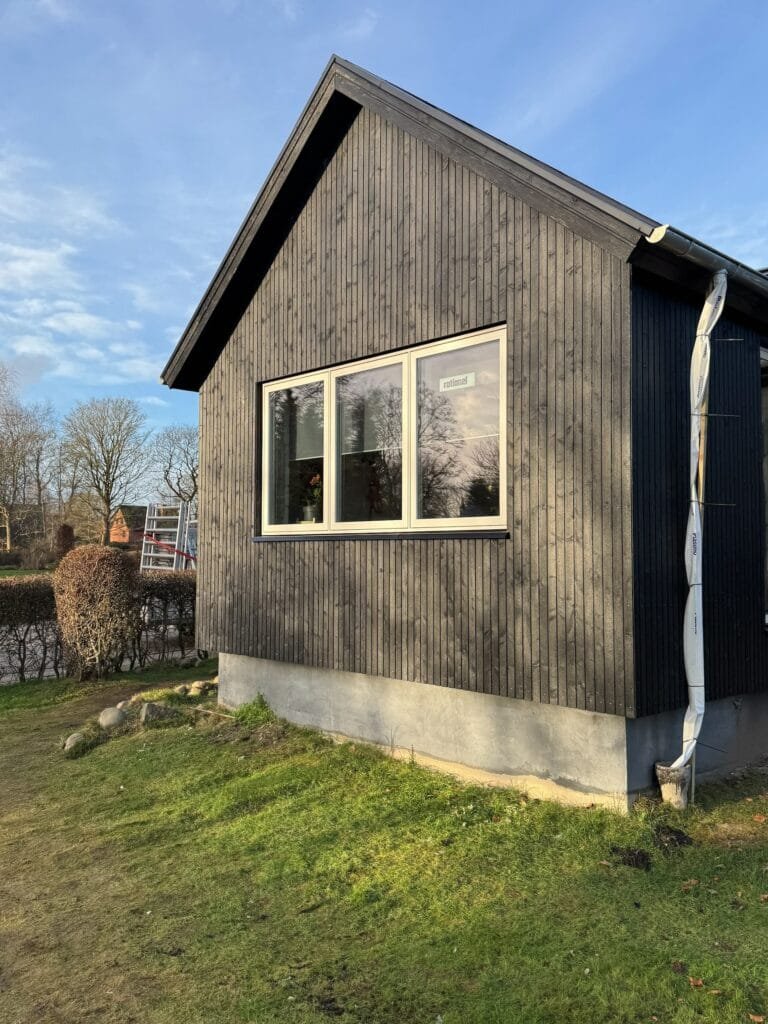 Moderne sort træhus med store vinduer