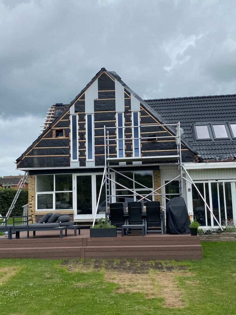 Hus under renovering med stillads og terrasse
