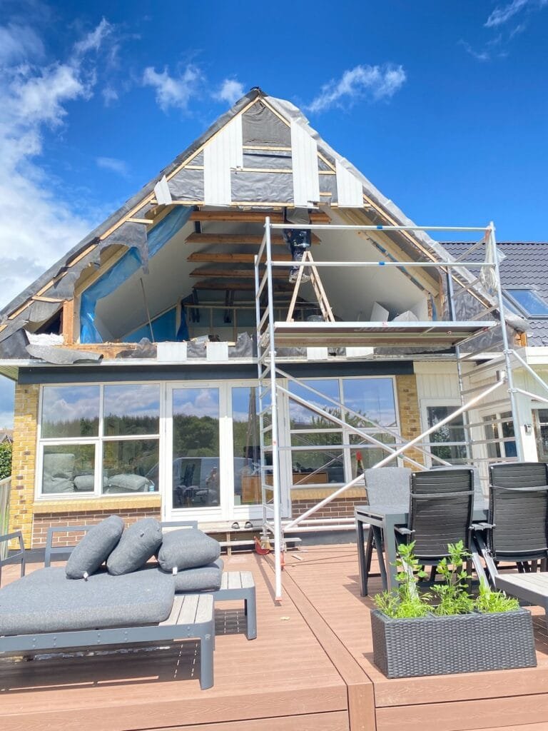 Hus under renovering med stillads og terrasse